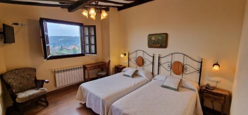- une chambre avec deux lits, une chaise et une fenêtre dans l'établissement El Mirador de Deva, à Deva