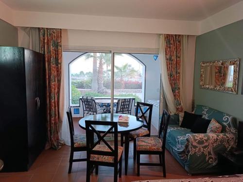sala de estar con mesa, sillas y sofá en Bellissimo appartamento vista mare sulla piscina, en Sharm El Sheikh