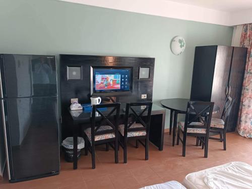 - un salon avec une table, des chaises et une télévision dans l'établissement Bellissimo appartamento vista mare sulla piscina, à Charm el-Cheikh