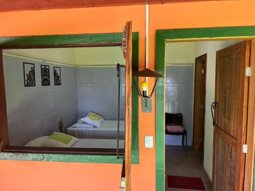 een slaapkamer met een bed door een deuropening bij Casa de Roça in São João Batista do Glória