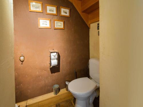 a bathroom with a toilet and pictures on the wall at Tranquil Home in Tinlot in Tinlot