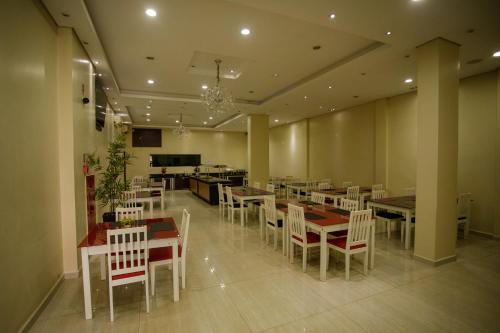 un comedor con mesas y sillas blancas en Atrium Express Hotels en Parauapebas