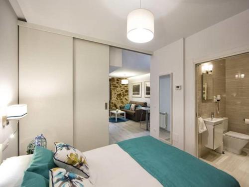 a bedroom with a large bed and a bathroom at Bolboreta Dreams Apartamentos Turísticos in Santiago de Compostela