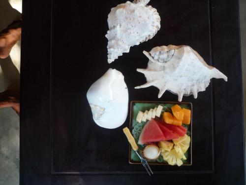 a plate of food with a shell and a plate of fruit at Gili Nyepi in Gili Trawangan