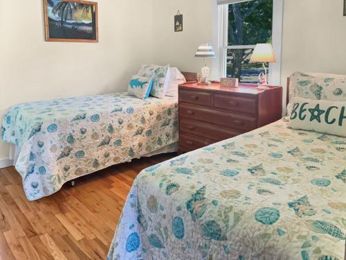 Un dormitorio con dos camas y una cómoda. en 6 Locust Street South Yarmouth Cape Cod- -Timeless Memories, en South Yarmouth