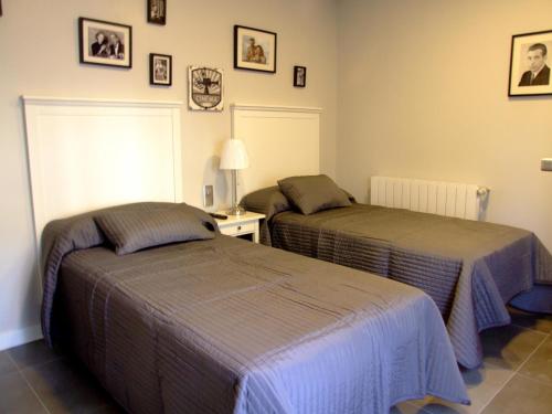 a bedroom with two beds and a table with a lamp at Hostal Vintage Santander in Santander