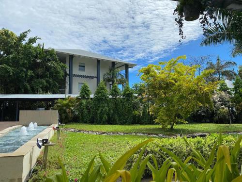 a house with a garden with a fountain in the yard at Heritage Park Hotel in Honiara