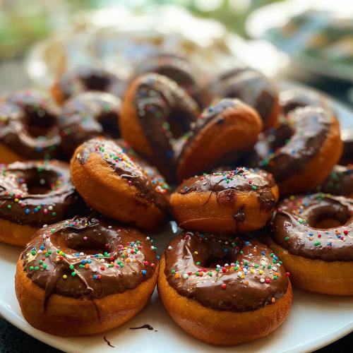 a plate of chocolate covered donuts with sprinkles at Heritage Park Hotel in Honiara
