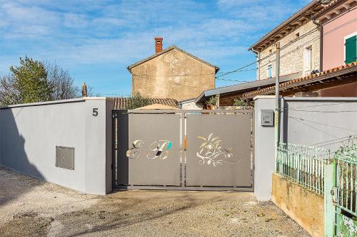 a gate with graffiti on it in front of a house at Family friendly house with a swimming pool Butkovici, Central Istria - Sredisnja Istra - 20751 in Svetvinčenat