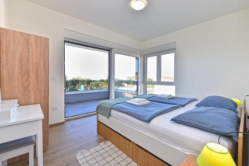 - une chambre avec un lit doté d'oreillers bleus et d'une fenêtre dans l'établissement Family friendly house with a swimming pool Peroj, Fazana - 20755, à Vodnjan