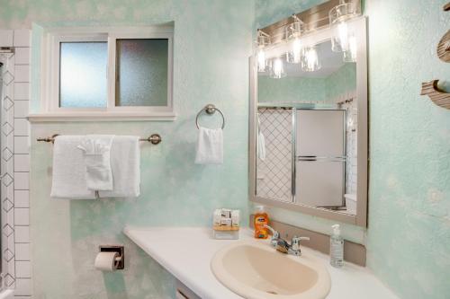 a bathroom with a sink and a mirror and towels at Sunset Seabreeze in Neskowin