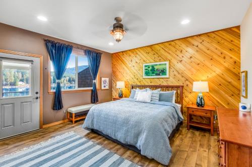 a bedroom with a bed and a wooden wall at Cain Lake Lodge in Sedro-Woolley