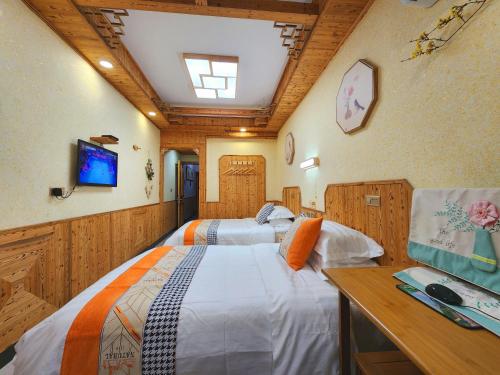 a bedroom with two beds and a desk and a tv at Nanxi JiangTingXuanGe Homestay in Yongjia