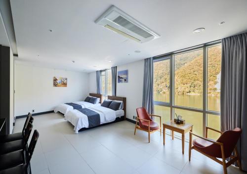 YJ Hotel في كابيونغ: غرفة نوم بسرير ونافذة كبيرة