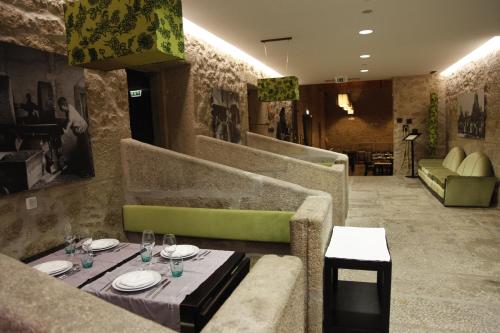 a restaurant with a table and a green couch at Casas do Regato in Castelo Branco
