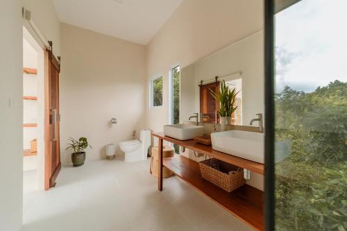 La salle de bains est pourvue de 2 lavabos et d'un miroir. dans l'établissement Villa Pandora, à Wok Tum
