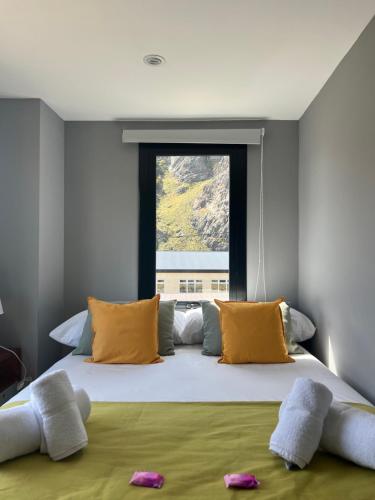 a bedroom with a large bed with yellow pillows and a window at Desierto Suites in El Chalten