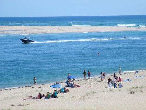 a group of people on a beach with a boat at 388 Main Street Chatham Cape Cod - - The Priscilla House in Chatham