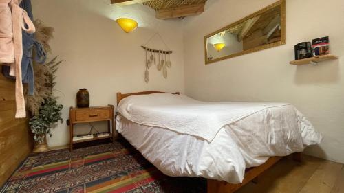 a small bedroom with a bed and a night stand at Deluxe Taida Chalet in Villa de Leyva