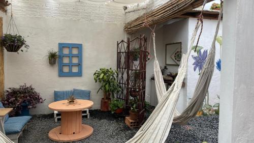 a patio with a hammock and a table and chairs at Deluxe Taida Chalet in Villa de Leyva