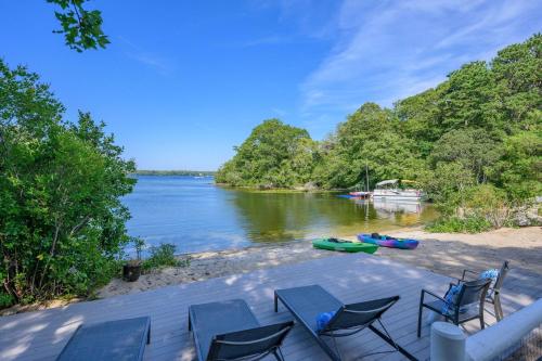 a deck with chairs and boats on the water at Relax by the Lake: Private Beach Views in Centerville