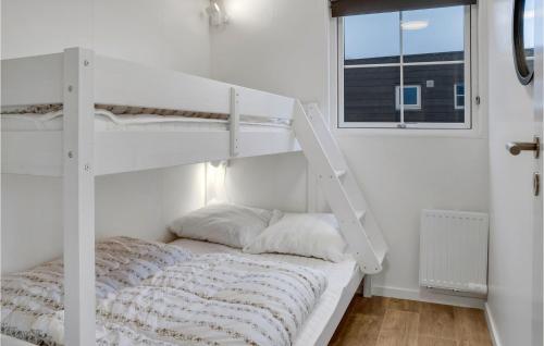 Ce lit superposé blanc se trouve dans une chambre blanche dotée d'une fenêtre. dans l'établissement 2 Bedroom Nice Apartment In Vggerlse, à Bøtø By