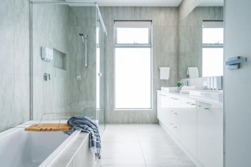uma casa de banho branca com uma banheira e um chuveiro em La Via Del Mare - SUNDAY FOR FREE em Dromana