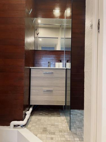 - une cuisine avec des murs en bois et un comptoir avec un évier dans l'établissement Belle chambre Champs-Élysée, à Paris