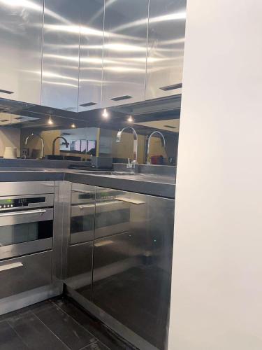 une cuisine équipée d'armoires et d'appareils en acier inoxydable dans l'établissement Belle chambre Champs-Élysée, à Paris