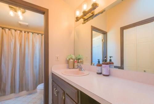 La salle de bains est pourvue d'un lavabo, de toilettes et d'un miroir. dans l'établissement 17 Woodland Avenue Mashpee Cape Cod - - The Cape Escape, à Mashpee