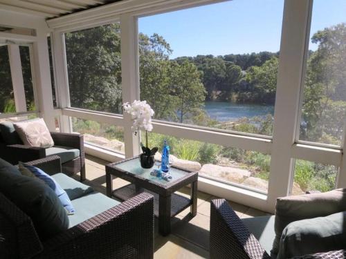 a living room with a large window with a view of a river at 151 Sky Way Chatham Cape Cod- -Cape Time in Chatham
