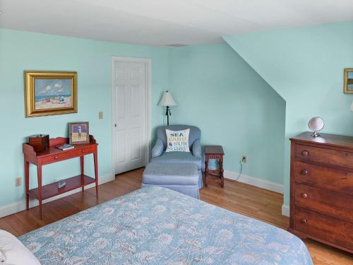 a bedroom with a bed and a table and a chair at 151 Sky Way Chatham Cape Cod- -Cape Time in Chatham