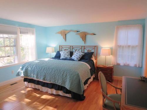 a bedroom with a bed with blue walls and a television at 151 Sky Way Chatham Cape Cod- -Cape Time in Chatham