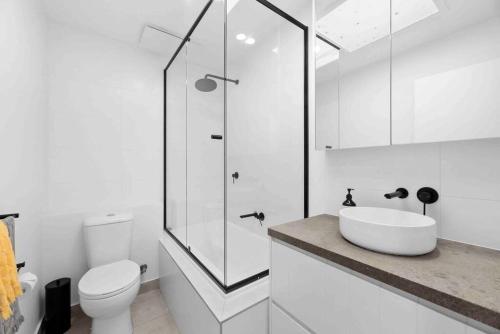 a white bathroom with a sink and a shower at So Beachy! 200m to the beach or shops! Sleeps 8 in Ocean Grove