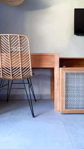a wicker chair sitting next to a wooden desk at Umadewi Surf & Retreat in Pulukan