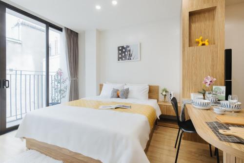 a hotel room with a bed and a desk and a window at Myrcella Urban Studio in Hanoi