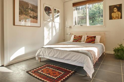 ReidsdaleにあるMonga Mountain Retreatのベッドルーム1室(ベッド1台、窓、ラグ付)