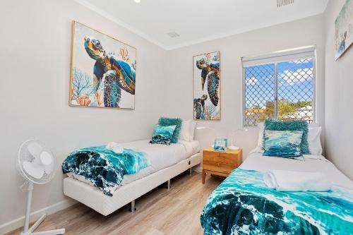 a bedroom with two beds and a window at 12 Calming Coral Beach Beautiful 2brm in Perth