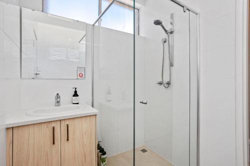 ein Bad mit einer Dusche und einem Waschbecken in der Unterkunft 12 Calming Coral Beach Beautiful 2brm in Perth