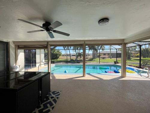 uma sala de estar com uma ventoinha de tecto e uma piscina em Sunshine Paradise em Cape Coral