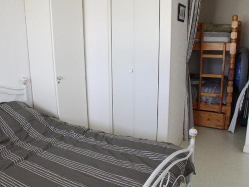 - une chambre avec un lit et des armoires blanches dans l'établissement Appartement tout confort proche plage avec parking privé - FR-1-482-8, à Fort-Mahon-Plage