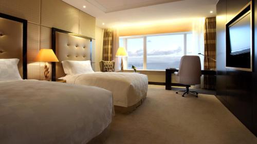 a hotel room with two beds and a window at InterContinental Dalian, an IHG Hotel in Dalian