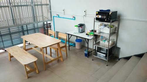 Ban Khlong PrawetにあるView Dee BKK Airport Residenceのテーブル、椅子2脚、デスクが備わる教室です。