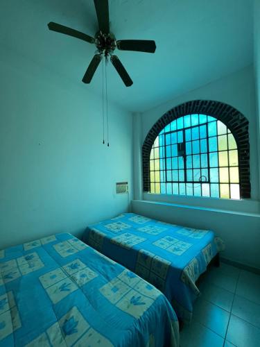 una camera con 2 letti e un ventilatore a soffitto di La casa club a Oacalco