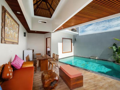 ジンバランにあるAvery Le Nixsun Villas Uluwatu by Waringin Hospitalityのリビングルーム(テーブル、ソファ付)のスイミングプールを利用できます。