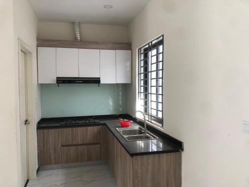 a kitchen with white cabinets and a sink and a window at Your living & working sanctuary near Phnom Penh in Phumĭ Kândal (2)