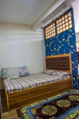 a bedroom with a bed and a blue wall at newa home in Pātan