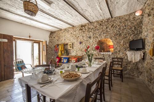 a dining room with a table and chairs and a television at La Magara in Civita