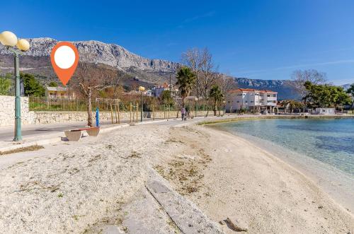 ein Straßenschild an einem Strand neben dem Wasser in der Unterkunft Apartments Helios in Kaštela