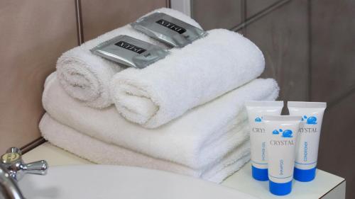 a pile of towels on a sink in a bathroom at Southern Comfort Motor Inn in Cootamundra